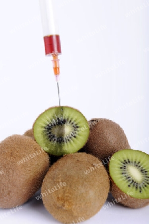 Spritze in Kiwi, Genkiwi, Symbolbild, Injektionsspuren in der Kiwi, genmanipulierte Lebensmittel
