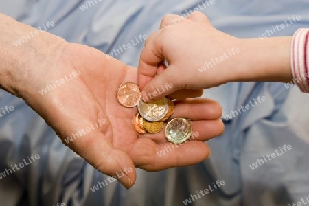 Hand der alte Frau und das kind mit den Kleingeld