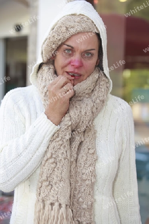 ?ltere Frau mit Grippe nimmt ein Hustenbonbon