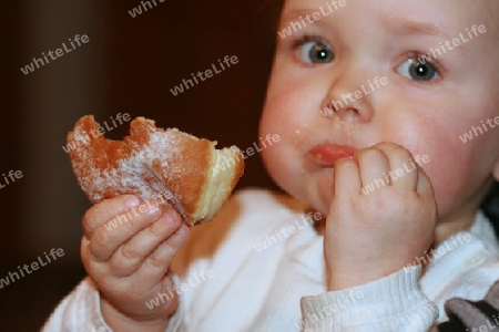 Kind beim Krapfen essen