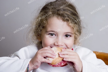 cute little girl eating a sandwich