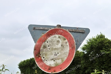 Detailed close up of bullet holes from gun shots in a german traffic sign