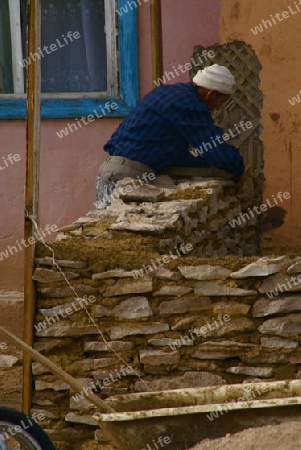 Mann baut Steinmauer