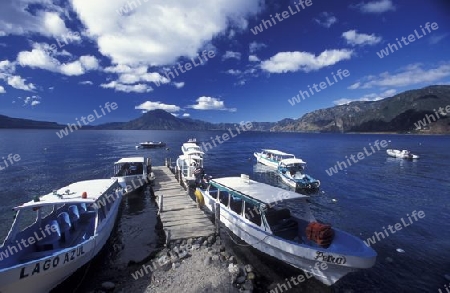 People at the coast of Lake Atitlan mit the Volcanos of Toliman and San Pedro in the back at the Town of Panajachel in Guatemala in central America.   