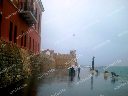 Touristen spazieren in Chania beim Unwetter