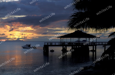 Ein Hotelstrand mit Pavillon bei Sonnenuntergang auf der Insel Praslin auf den Seychellen im Indischen Ozean.