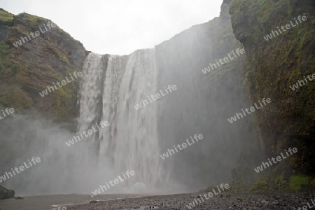 Der S?den Islands, am  malerischen Wasserfall Skogafoss, der hier in einer Breite von 25 Metern bis zu 60 Meter tief ?ber die Flu?kante des Sk?g? herabst?rzt