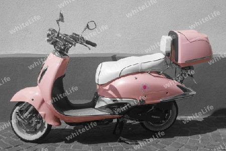 ein Motorroller, in pink, vor einer Hauswand