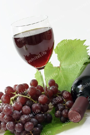 Rotwein mit roten Trauben auf hellem Hintergrund