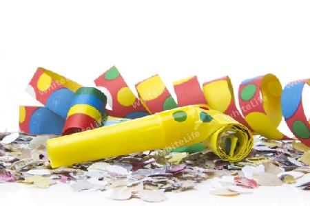 Luftschlangen und Konfetti als Partydekoration fuer Silvester und Feiern mit weissem Hintergrund