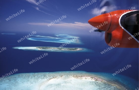 
Ein Wasserflugzeug in der Luft ueber den Inseln der Malediven im Indischen Ozean.  