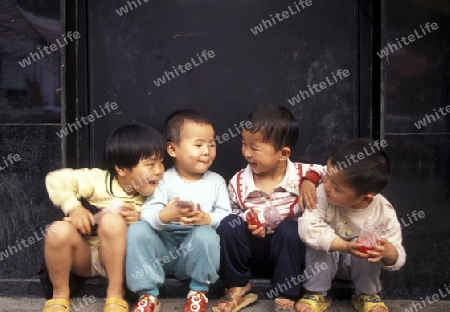 4 childern in a market street in the city of Shenzhen north of Hongkong in the province of Guangdong in china in east asia. 