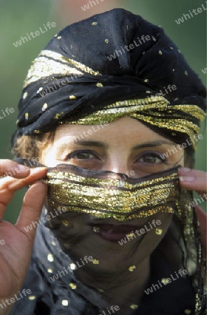 Eine Tunesische Frau in traditionellem Kopftuch  in Monastir am Mittelmeer im Nordosten von Tunesien in Nordafrika.
