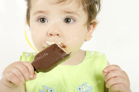 Baby girl eating an ice cream mini