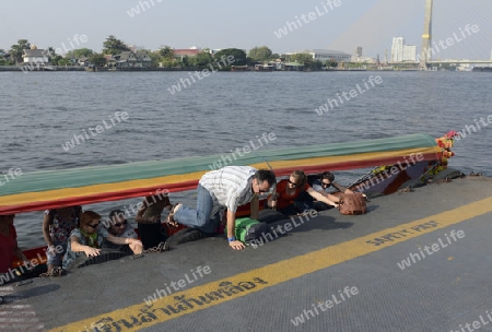 Touristen steigen aus einem traditionellen Holzboot auf dem Mae Nam Chao Phraya River in der Hauptstadt Bangkok von Thailand in Suedostasien.