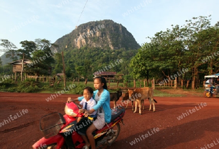 Die Landstrasse 12 beim Dorf Mahaxai Mai von Tham Pa Fa unweit der Stadt Tha Khaek in zentral Laos an der Grenze zu Thailand in Suedostasien.