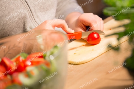 Child is cutting tomatoes