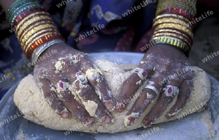 a women is making Bread in the town of Jaisalmer in the province of Rajasthan in India.