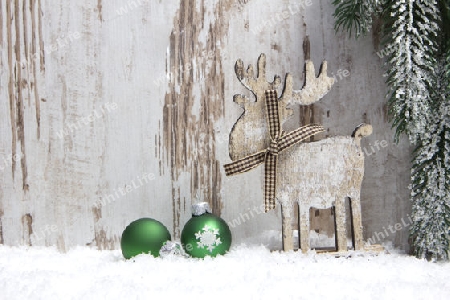Weihnachten, Dekoration mit Holzhintergrund, Schnee, Elch, Weihnachtskugeln gr?n und einem Tannenzweig 
