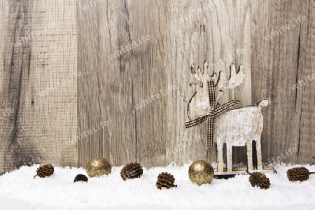 Weihnachten, Dekoration mit Holzhintergrund, Schnee, Elch, Weihnachtskugeln gold und Tannenzapfen