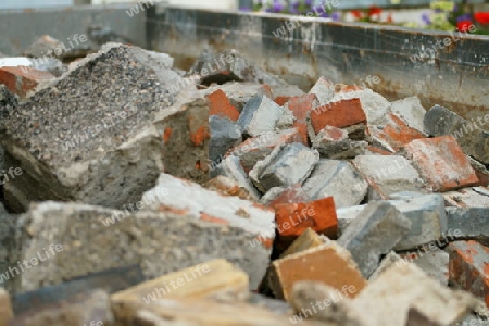 Steine von einem abgerissenen Haus in einem Bauschuttcontainer.