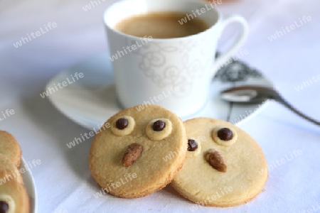 Zwei kekse in der form von eule und eine tasse kaffee fuer eine schoene pause