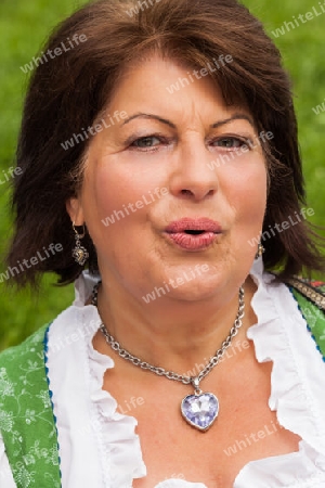 Portrait einer bayerischen Frau im Dirndl mit guter Laune
