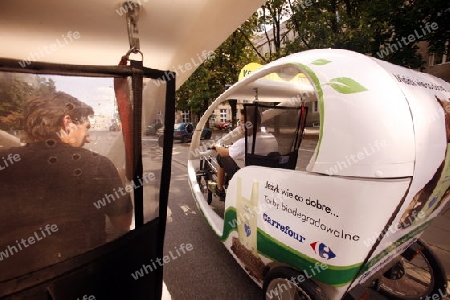 A Electro Taxi in the Old Town in the City of Warsaw in Poland, East Europe.