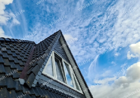Open roof window in velux style with black roof tiles