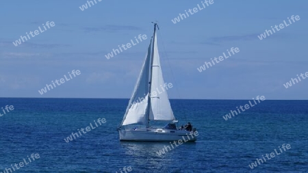 Weiße Segelyacht auf blauem Meer