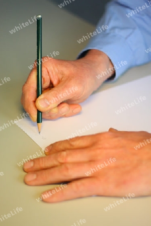 Mitarbeiter schreibt Notiz auf Papier