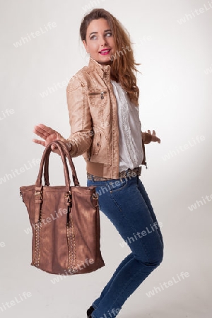 Spielerisch attraktive Frau mit einer Handtasche aus Lede