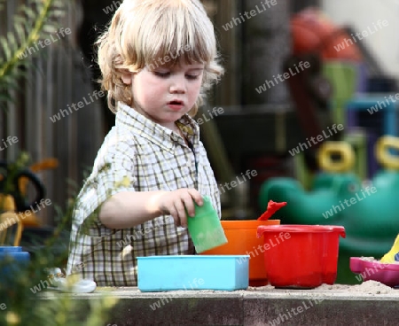 Kind spielt mit Sandzeug