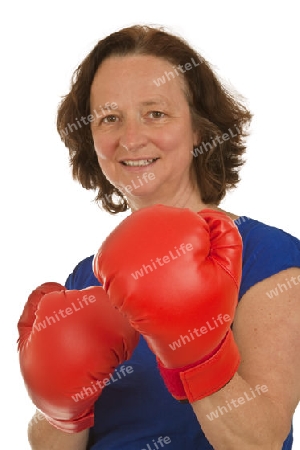 Frau mittleren Alters mit roten Boxhandschuhen freigestellt auf weissem Hintergrund