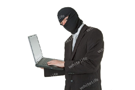 Mann mit Sturmhaube und Laptop freigestellt auf weeissem Hintergrund