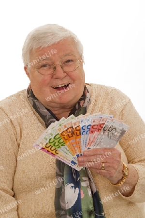 Seniorin mmit Banknoten auf hellem Hintergrund