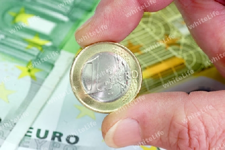 Ein Euro M?nze mit Geldscheinen im Hintergrund