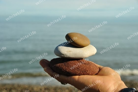 Holding Stones in front of the sea