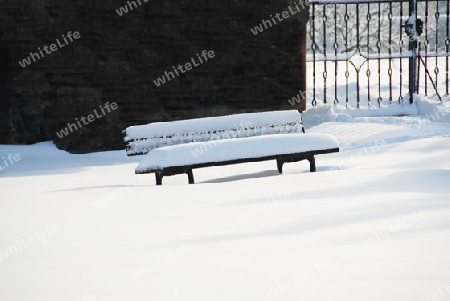 Verschneite Sitzbank im Park