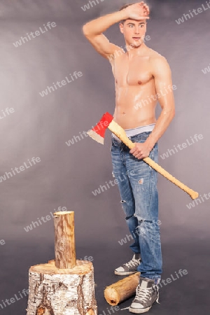 Muskul?re junger Mann hackt Brennholz