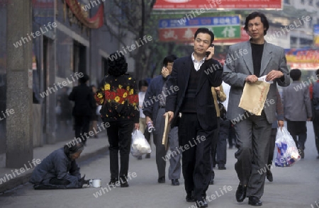 poor and Buisness People at the main square in the city of Chongqing in the province of Sichuan in china in east asia. 