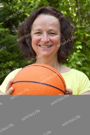 Sportliche Frau mit Basketball