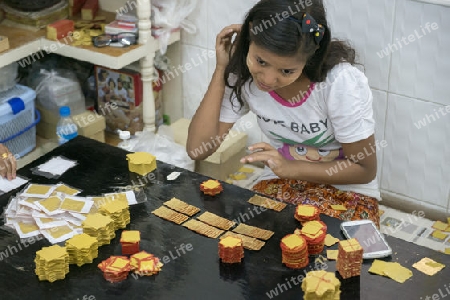 women control the sheets of Gold leaf at a Gold pounder Factory the City of Mandalay in Myanmar in Southeastasia.