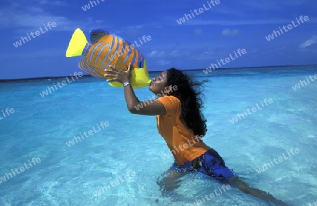
Der Strand mit einer Einheimischen Frau auf der Insel Helengeli im Northmale  Atoll auf den Inseln der Malediven im Indischen Ozean.