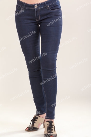 Frauenbeine mit blauer Jeans und modischen Schuhen