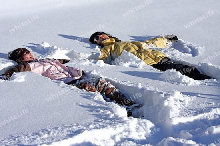 Mutter und Tochter im Schnee liegend