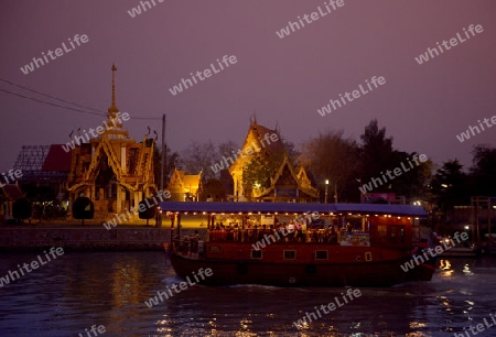 A smal Temple and a Evening Tour Boat on the River Chao Phraya in City of Ayutthaya in the north of Bangkok in Thailand, Southeastasia.