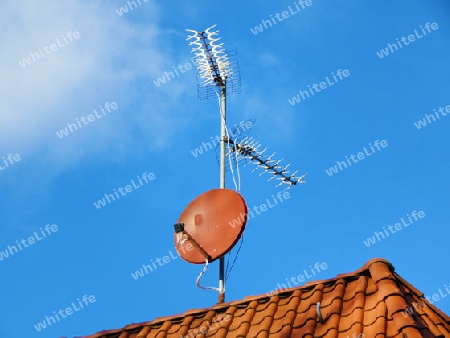 An old analog antenna and a satellite dish on the roof - Eine alte analoge Antenne und eine Satellitensch?ssel auf dem Dach