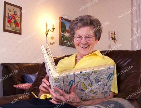 Seniorin schaut sich alte Fotos an