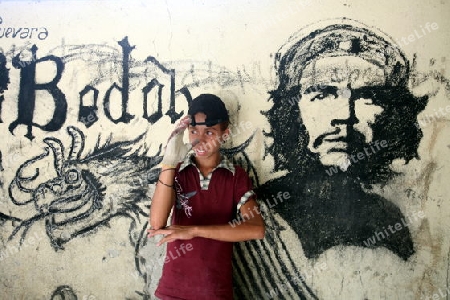 Ein Junge vor einem Che Bild bei Uatolari an der sued-ost Kueste von Timor auf der in zwei getrennten Insel Timor in Asien.